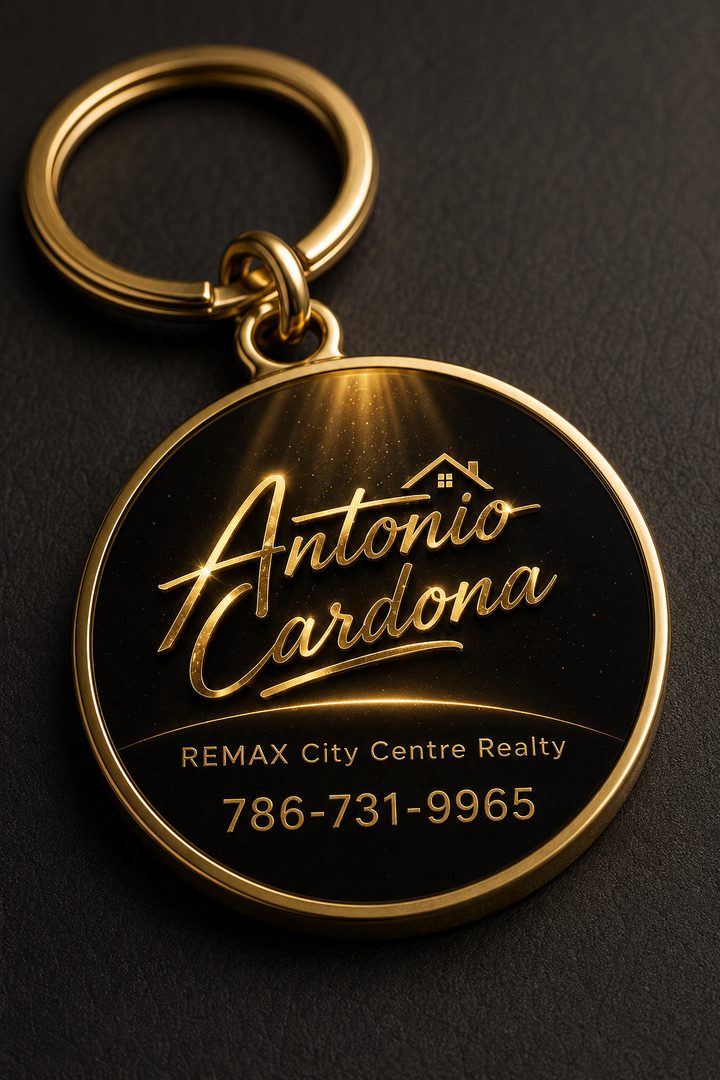 Un llavero redondo de oro con el logo de Antonio Cardona, RE/MAX City Centre Realty y el 786-731-9965